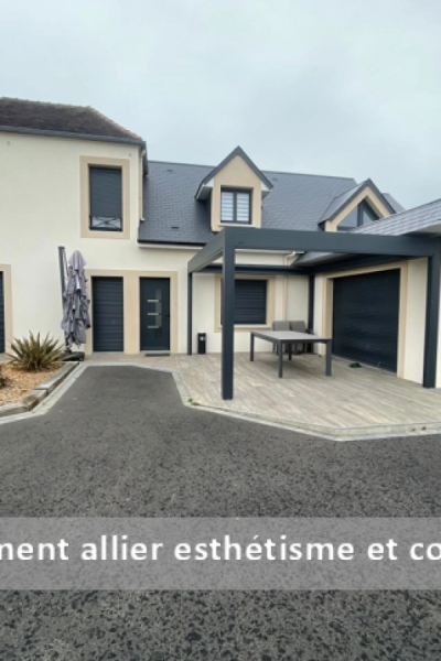 Maison crème avec pergola anthracite sur terrasse carrelée, menuiseries et porte garage assorties