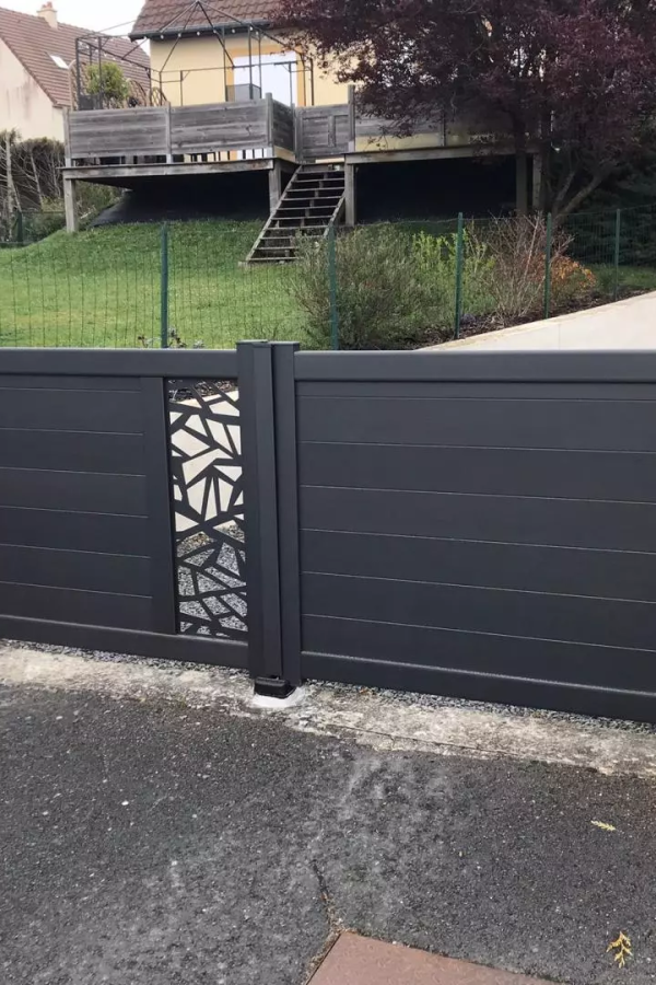 Clôture anthracite lames horizontales, motif ajouré géométrique sur muret, terrasse surélevée