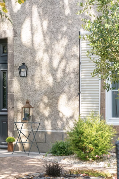 Façade crépi clair, fenêtre blanche stores horizontaux, ombres feuillage et applique
