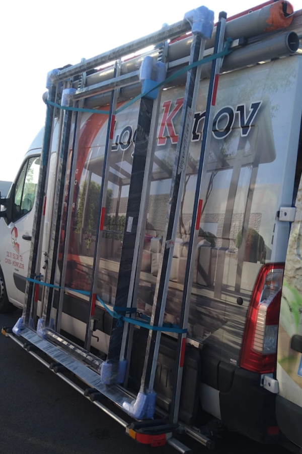 Fourgon blanc Logikinov sur pupitre latéral transportant châssis fenêtres emballés bleu