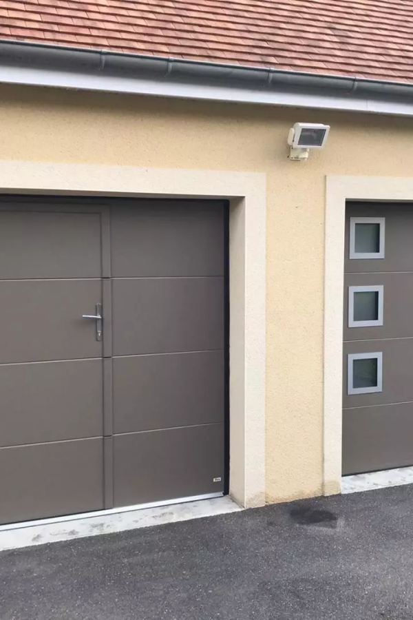 Deux portes garage sectionnelles taupe, portillon intégré à gauche et hublots à droite