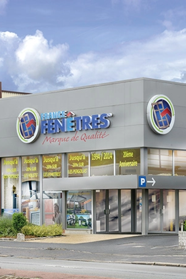 Façade magasin France Fenêtres avec vitrines annonçant promotions sur volets, fenêtres et pergolas