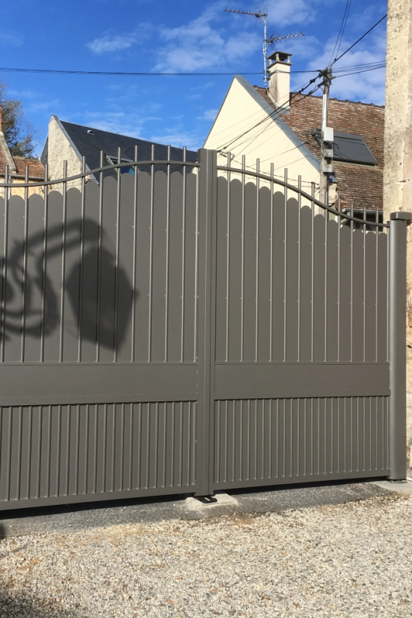Portail battant aluminium anthracite, partie ajourée festonnée et base pleine, gravier
