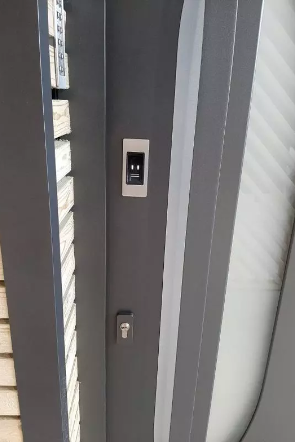 Gros plan porte anthracite avec lecteur empreinte, serrure et vitrage dépoli barres diagonales
