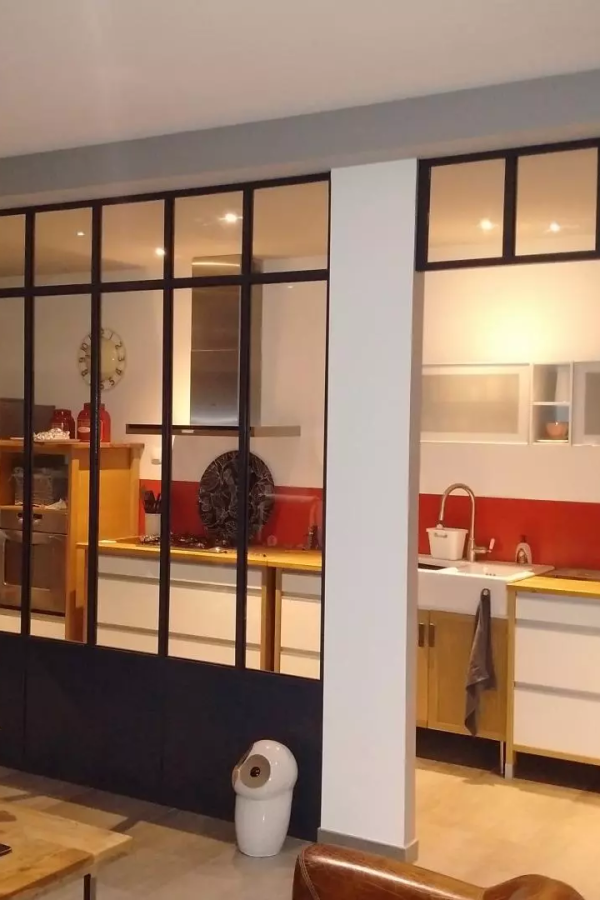 Verrière intérieure cadre noir séparant cuisine rouge moderne et pièce de vie claire