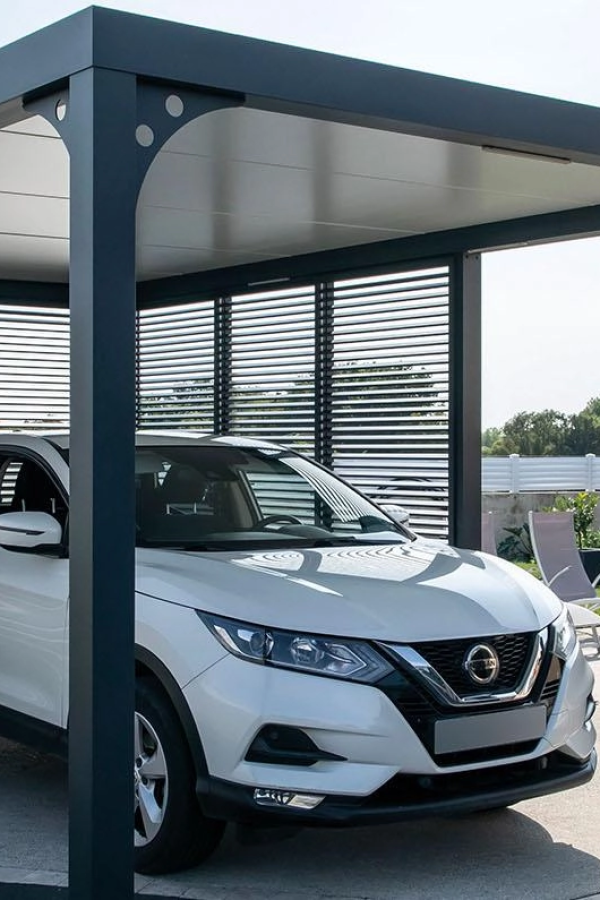 Carport aluminium anthracite avec lames latérales abritant un SUV blanc sur béton ensoleillé