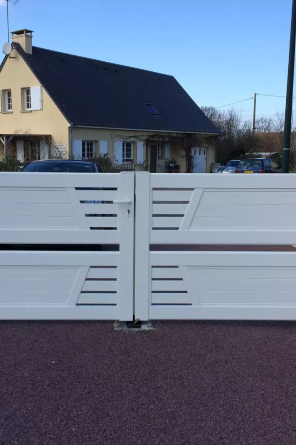 Portail battant blanc à lames horizontales ajourées devant maison individuelle façade crème