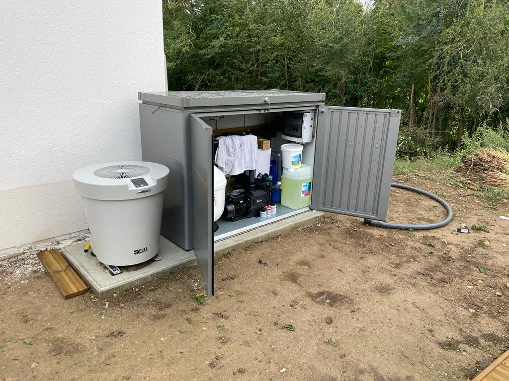Coffre métallique gris ouvert avec filtration piscine, pompe à chaleur FULL et tuyaux