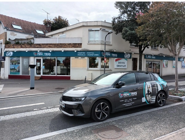 Agence France Fenêtres, enseignes bleues et voiture de service floquée devant magasin