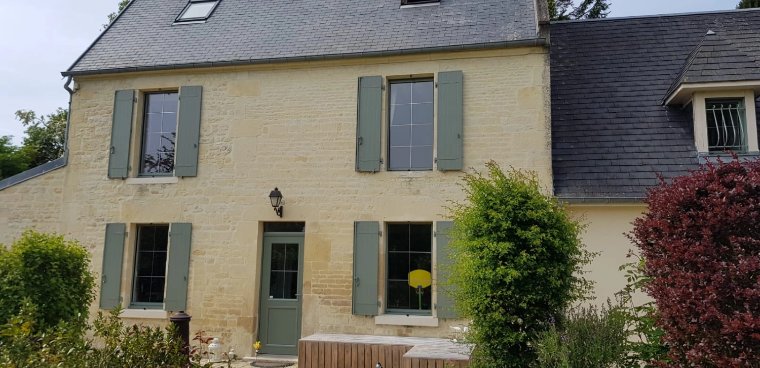 Maison pierre volets vert sauge, porte verte et lucarne, jardin fleuri