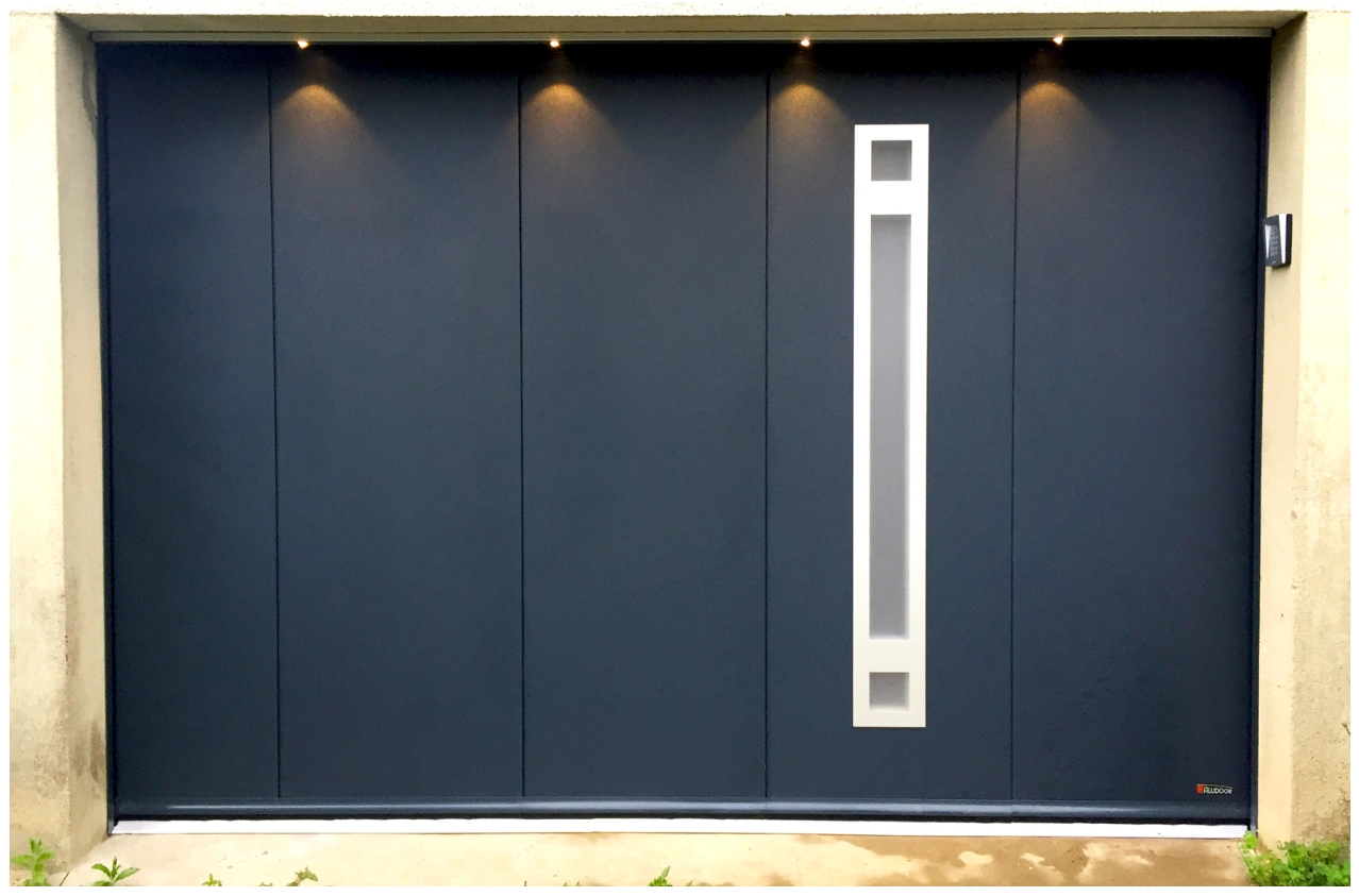 Porte garage anthracite panneaux verticaux, hublot vertical blanc et quatre spots linteau