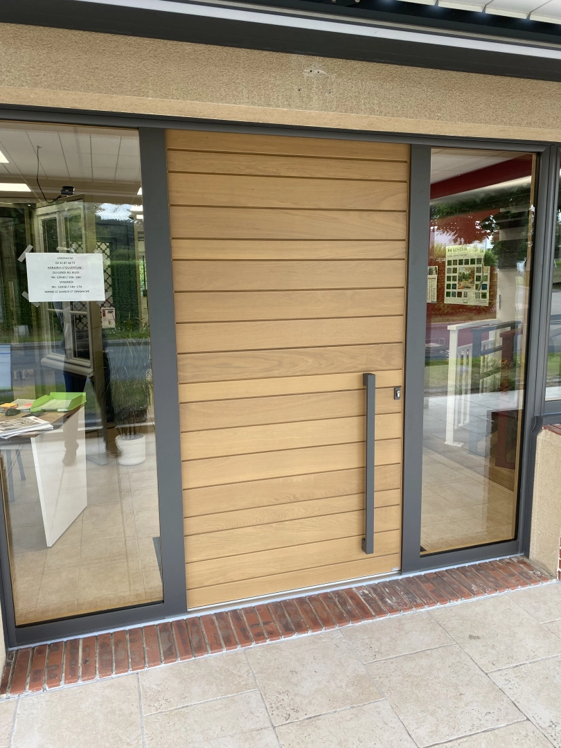 Porte bois lames et poignée verticale anthracite, vitrages latéraux et affiche horaires