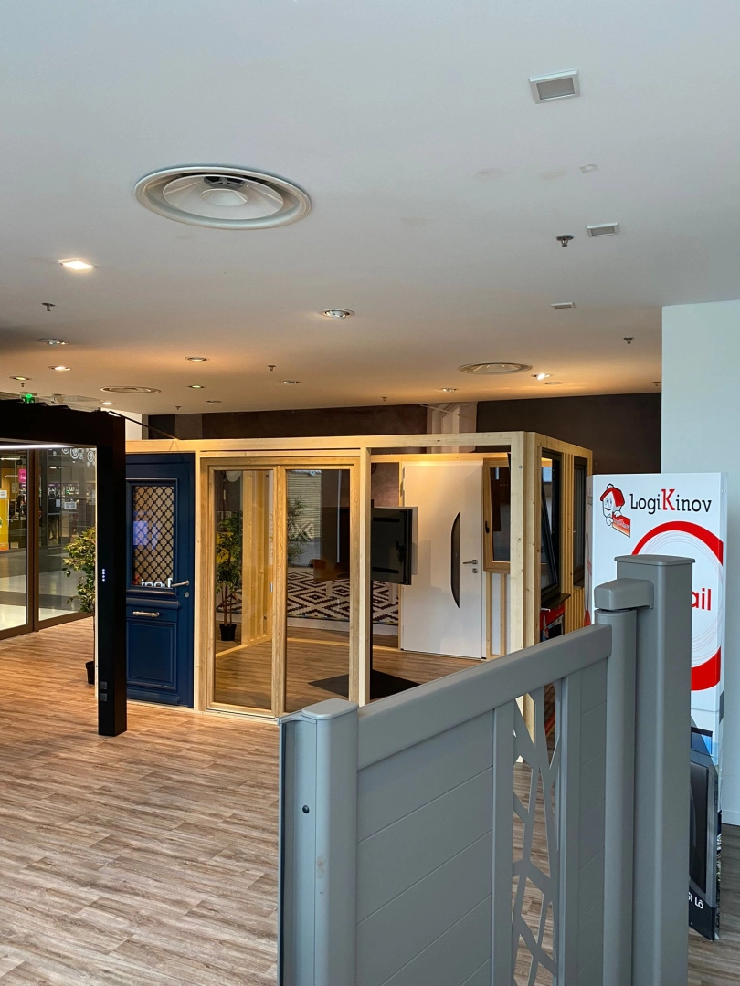 Showroom portail gris devant porte bleue, baie vitrée et porte blanche