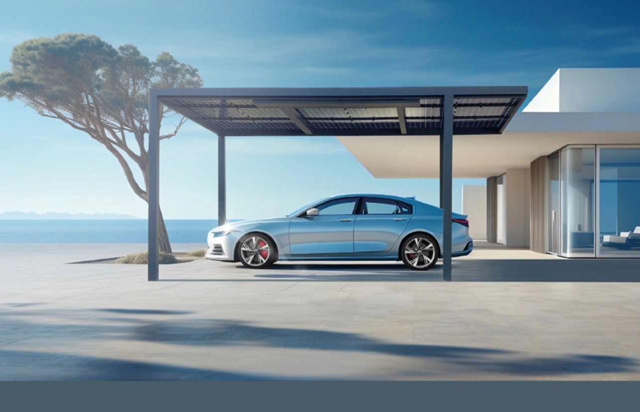 Carport solaire noir, voiture bleue devant villa blanche moderne face à la mer