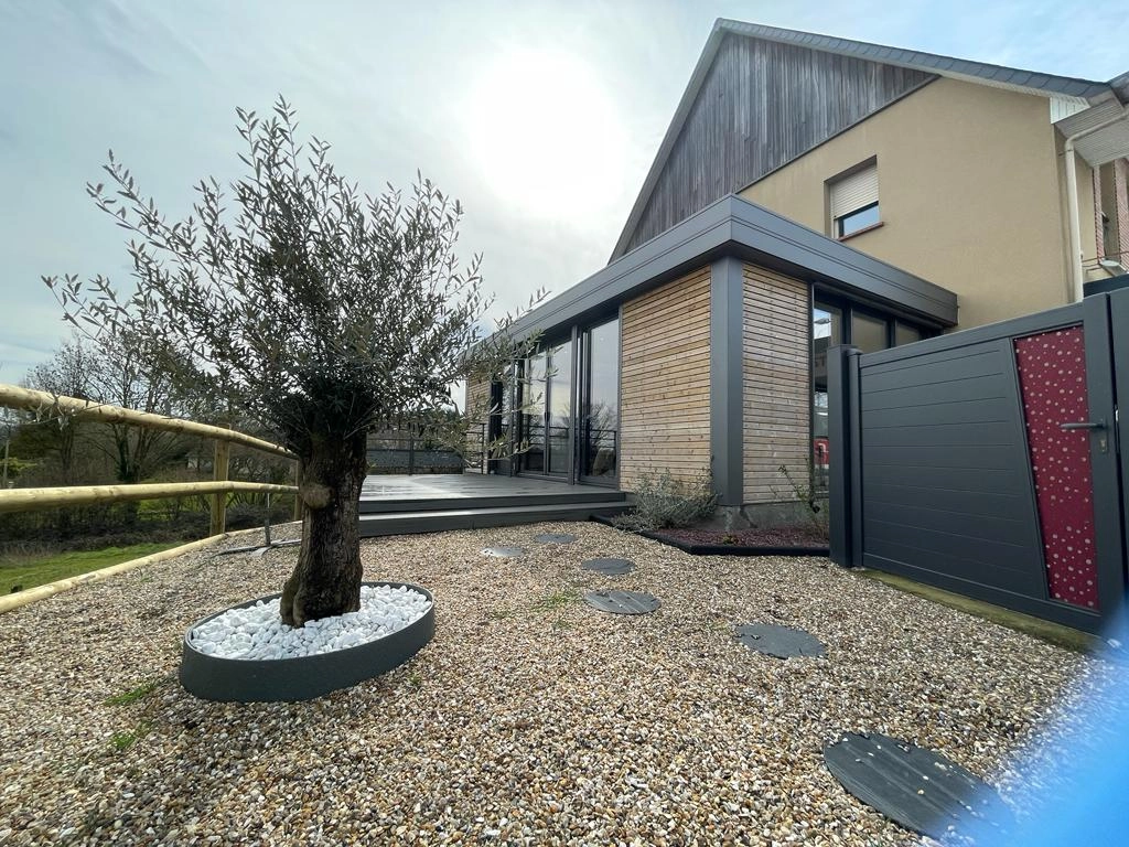 Extension bois et gris, terrasse composite, olivier en gravier blanc et portillon décor