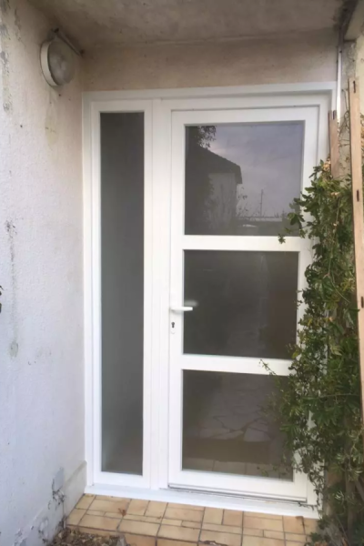 Porte d'entrée blanche à trois vitrages dépolis et tierce latérale assortie, mur crépi clair