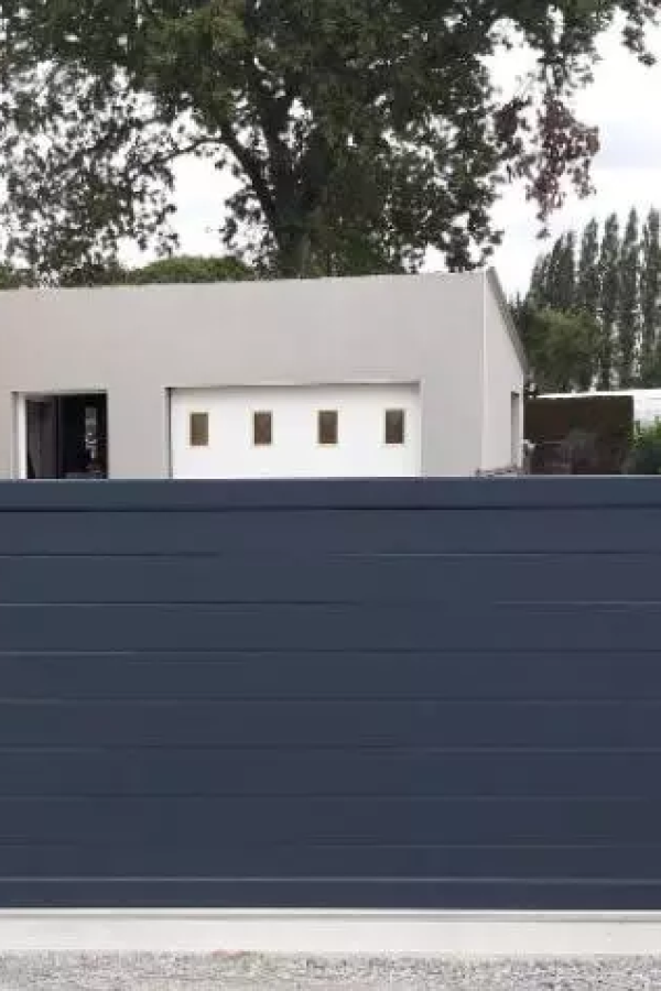 Portail coulissant anthracite à lames horizontales devant garage blanc à vitrages et maison