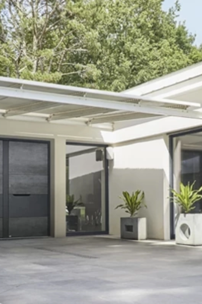 Terrasse maison blanche, pergola bioclimatique blanche et porte entrée anthracite texturée