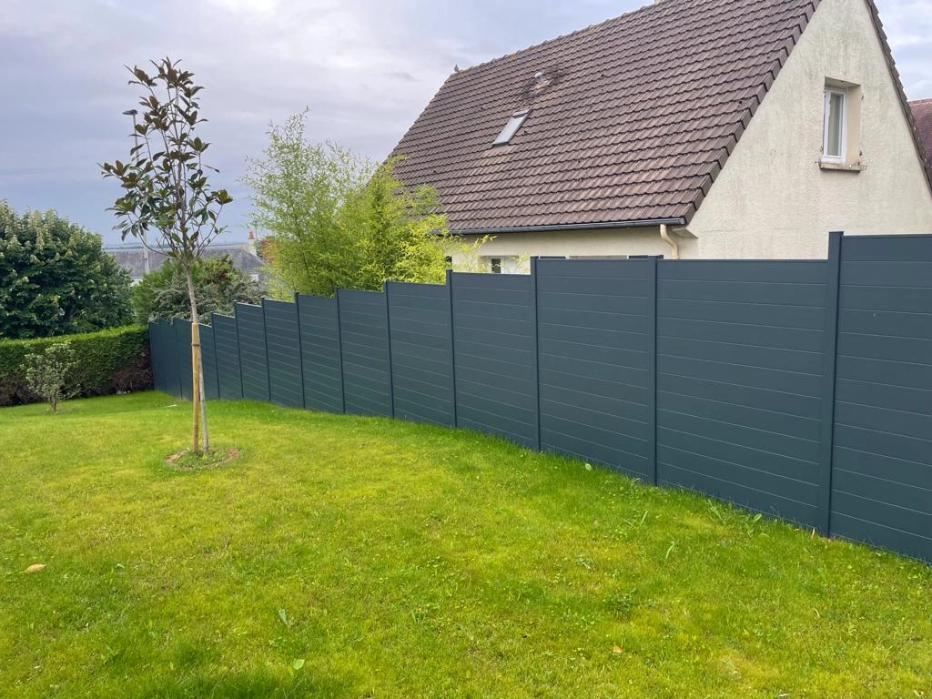 Cloture pleine anthracite lames horizontales en escalier sur pelouse devant maison