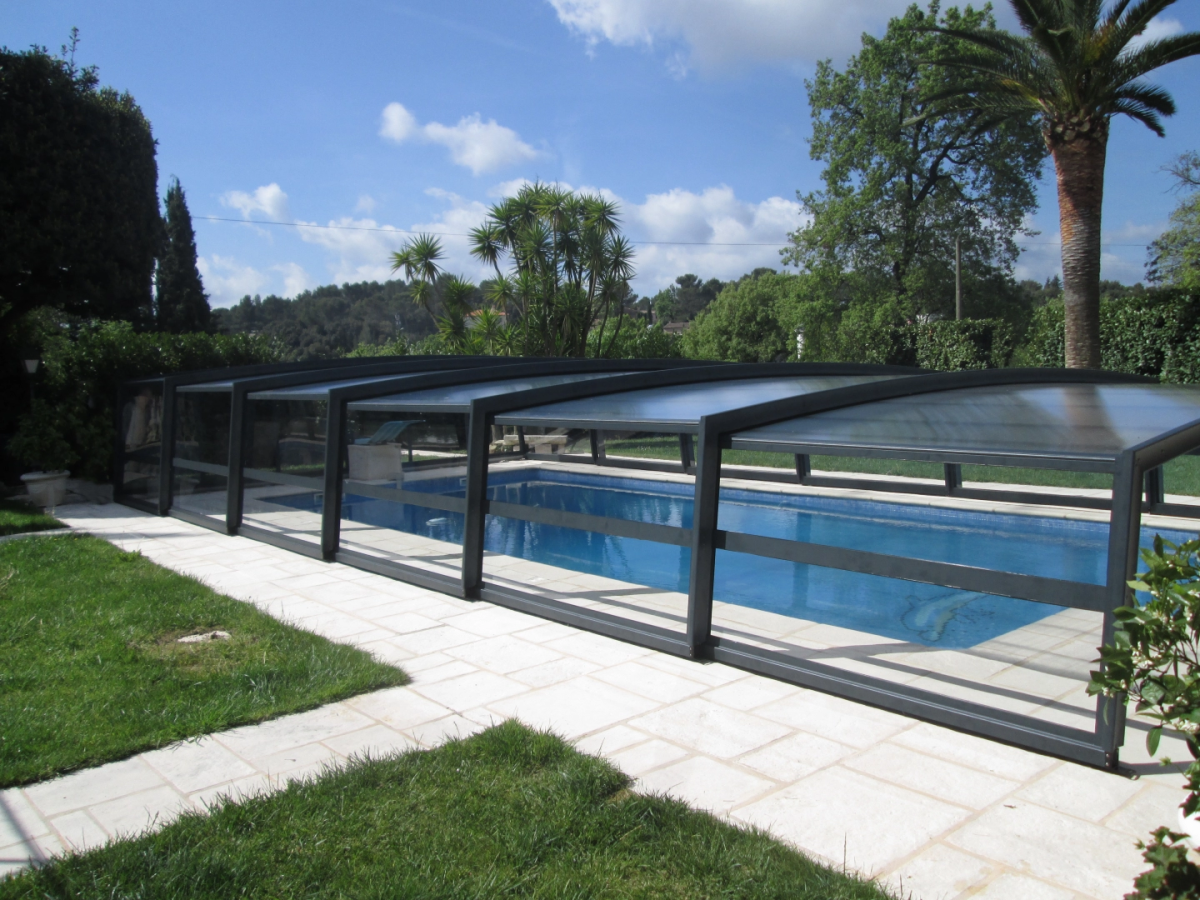 Abri piscine télescopique anthracite transparent, piscine rectangulaire, pelouse et palmier