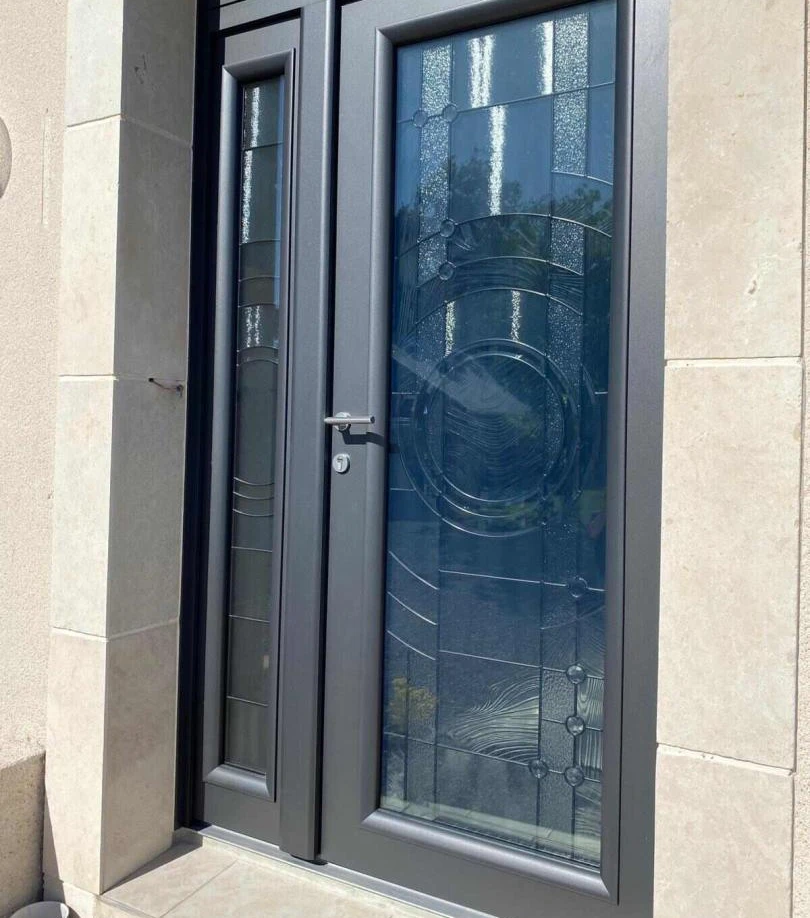 Porte anthracite vitrée, décor circulaire et bandes dépolies, imposte assortie, encadrement pierre claire