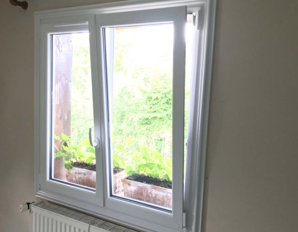 Fenetre PVC blanche a deux vantaux, un vantail basculant, jardin en contre-jour
