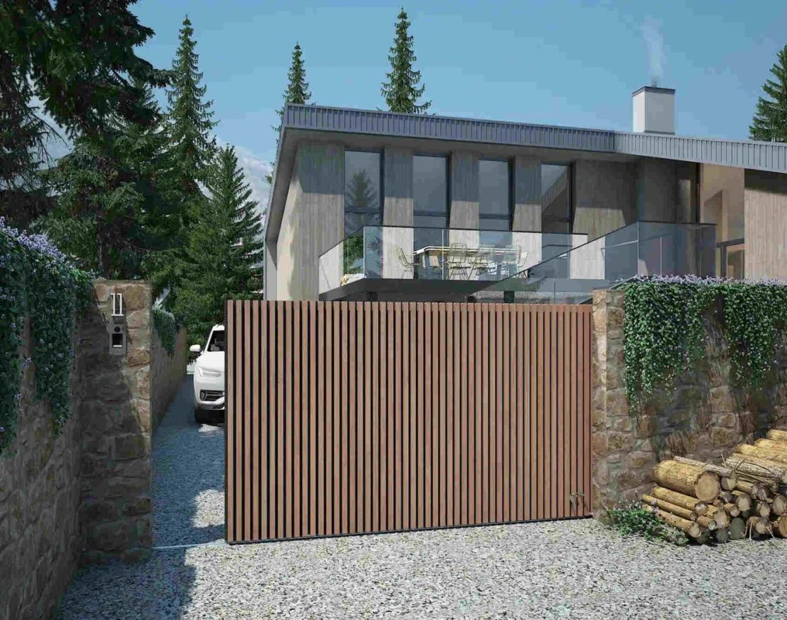 Portail coulissant lames bois clair entre murs en pierre devant villa contemporaine