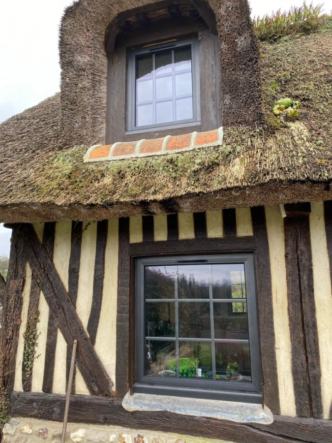 Maison colombages et chaume, fenêtres anthracite à petits bois dans lucarne et rez-de-chaussée