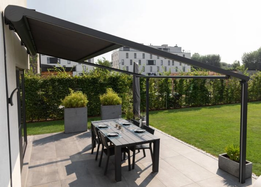 Pergola toile gris anthracite au-dessus d une table et chaises sur terrasse carrelée