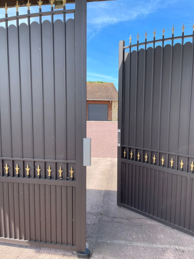 Portail battant anthracite ouvert avec pointes dorees devant garage anthracite assorti