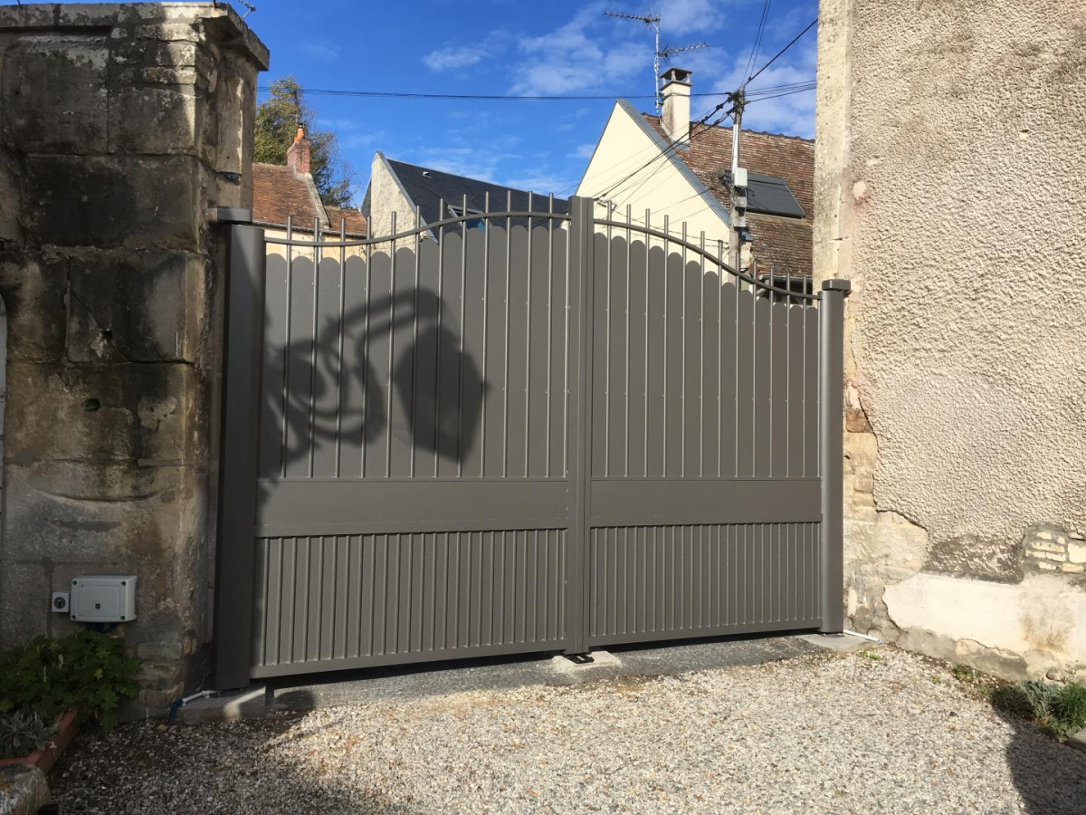 Portail battant double anthracite lames verticales chapeau bombe entre murs en pierre