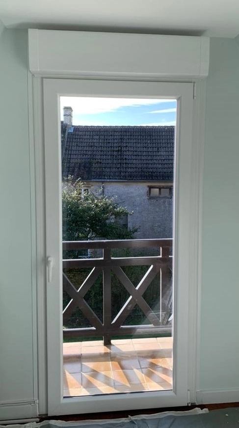 Porte-fenêtre PVC blanche, coffre volet roulant intégré, vue balcon tuiles et pierre