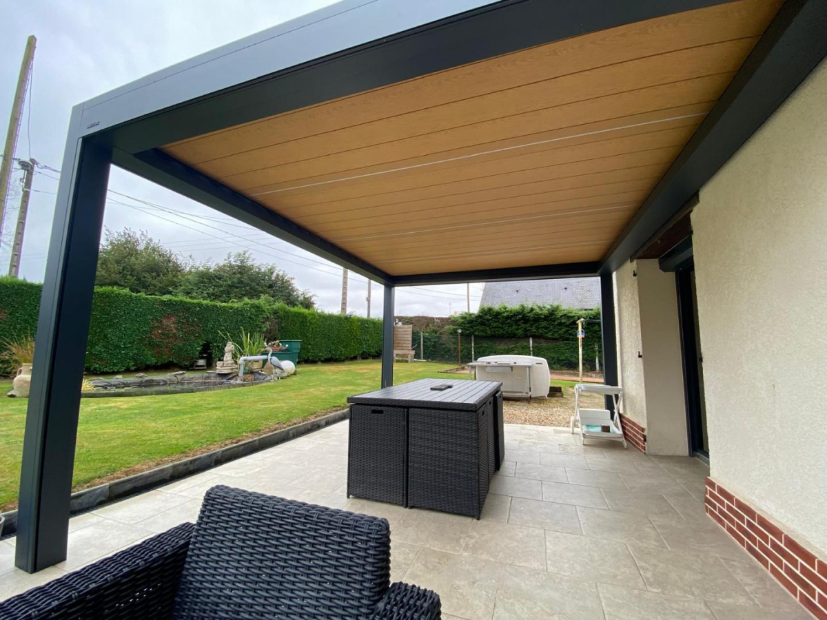 Pergola anthracite plafond lames aspect bois sur terrasse carrelée et mobilier noir