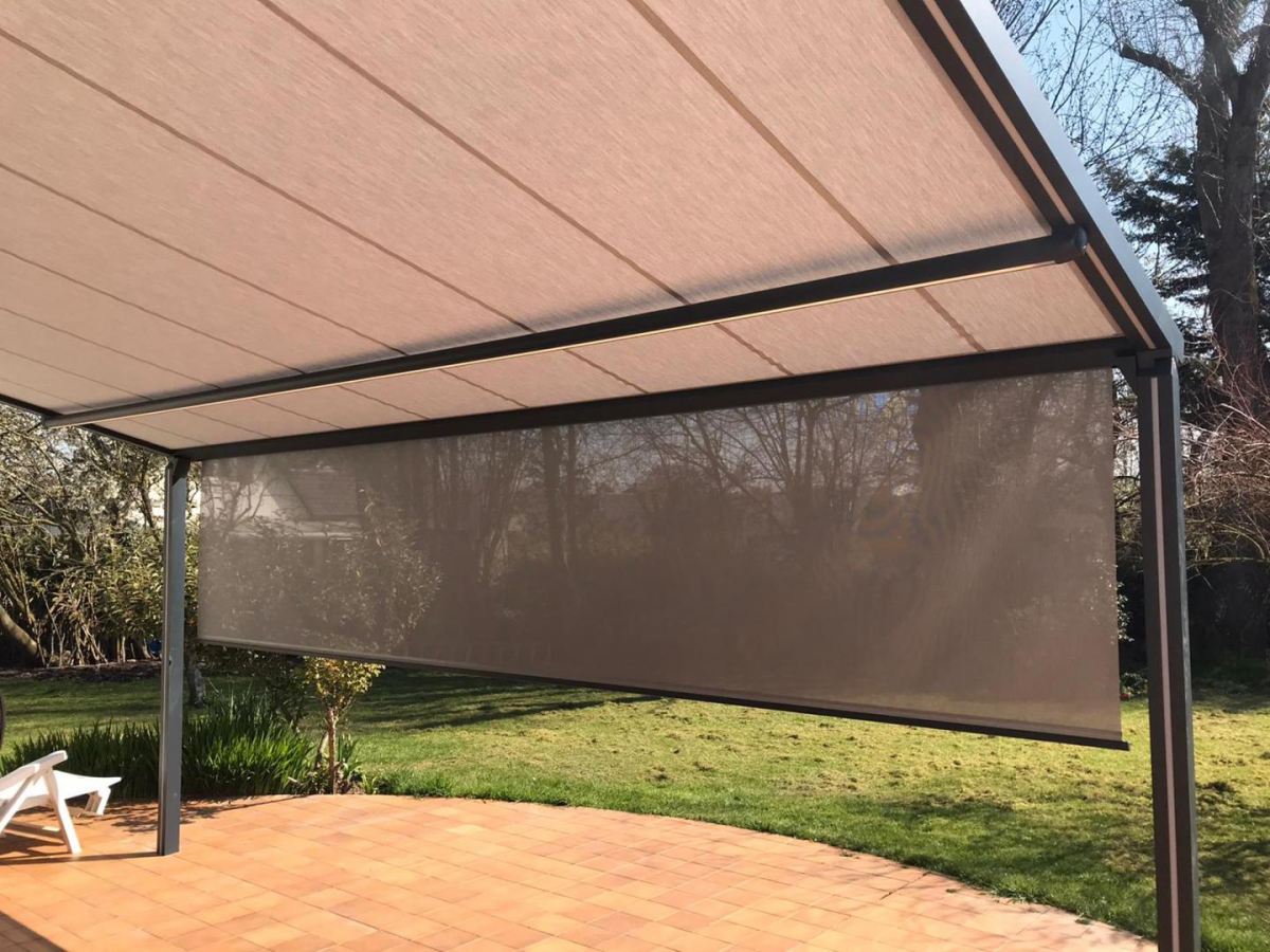 Pergola toit toile beige avec bandeau LED et store lateral sur terrasse carrelée