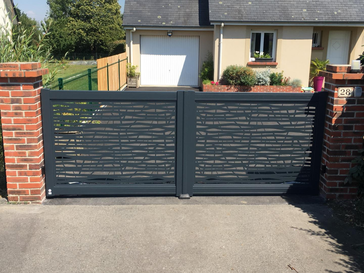 Portail battant anthracite motif ondule découpé laser entre piliers brique rouge