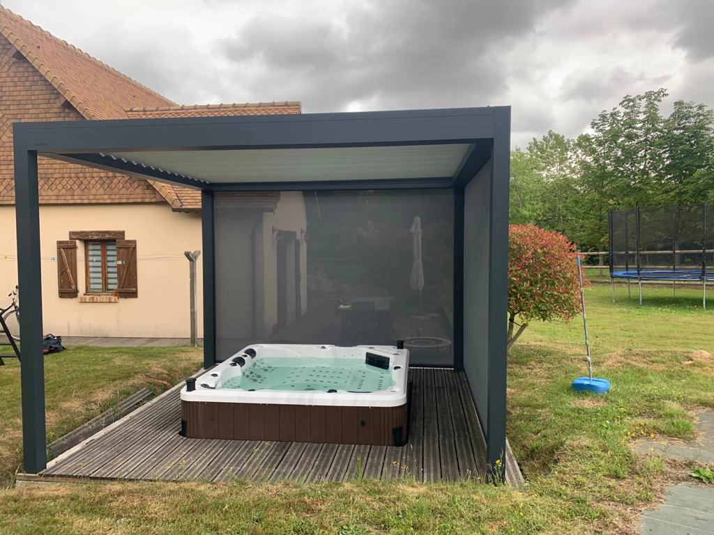 Pergola bioclimatique anthracite avec stores latéraux, spa carré sur terrasse bois grise