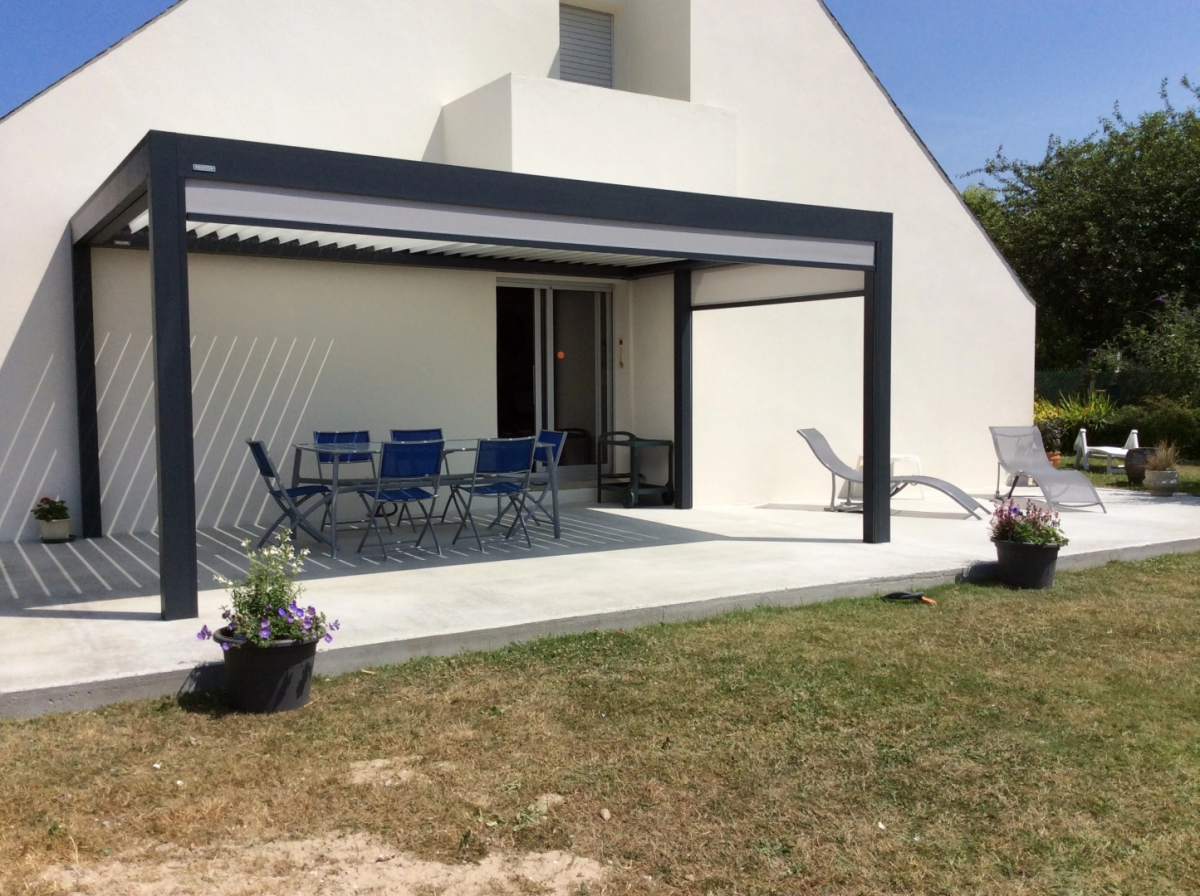 Pergola bioclimatique anthracite avec store lateral gris sur terrasse beton