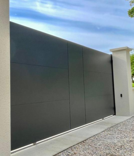 Portail coulissant anthracite plein panneaux horizontaux entre piliers beiges avec digicode