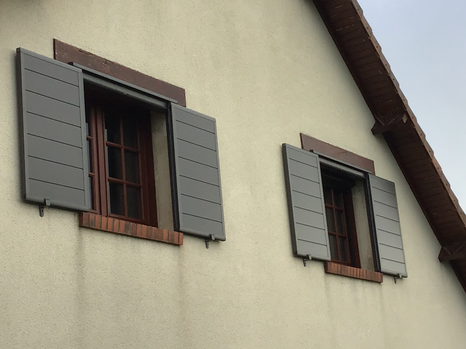 Volets coulissants anthracite sur une façade de maison