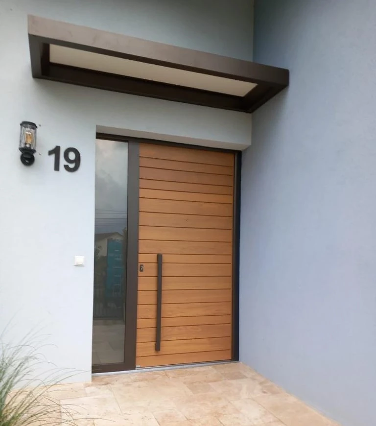 Porte bois lames horizontales, poignée noire verticale, marquise, numéro 19, mur bleu gris