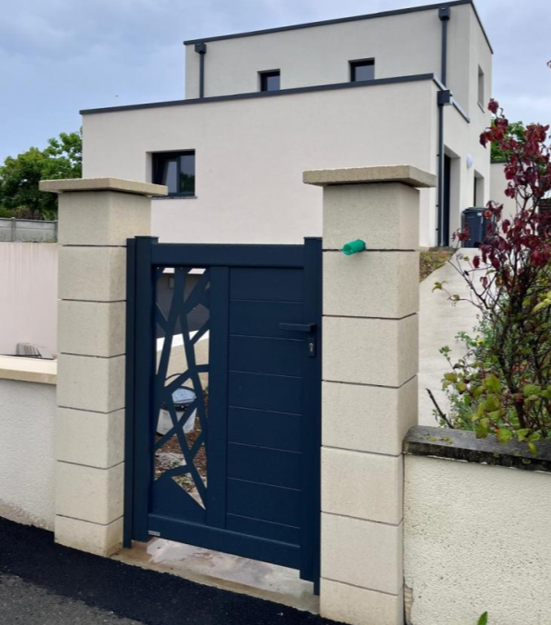 Portillon anthracite motif geometrique découpé et lames devant maison cubique beige