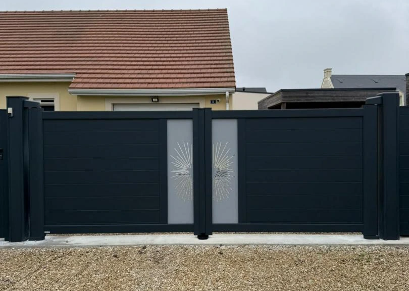 Portail battant anthracite lames horizontales et inserts vitres motif soleil sur gravier