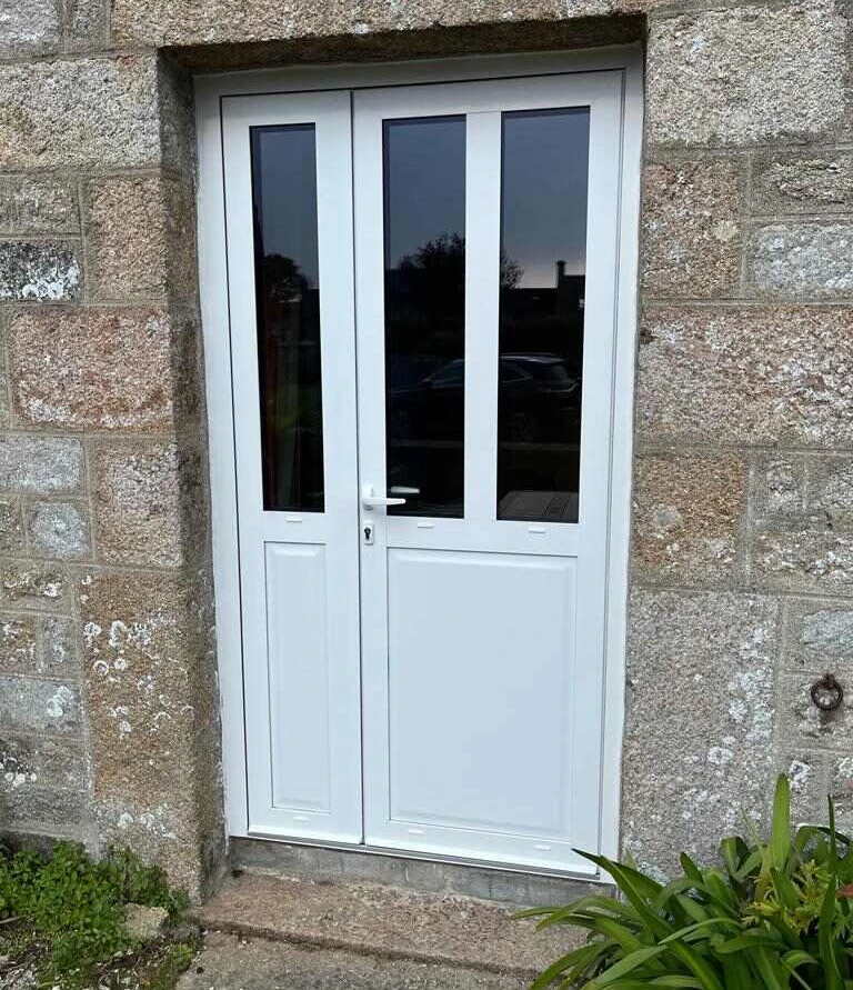 Porte PVC blanche deux vantaux inégaux, vitrages verticaux, encadrement pierre naturelle