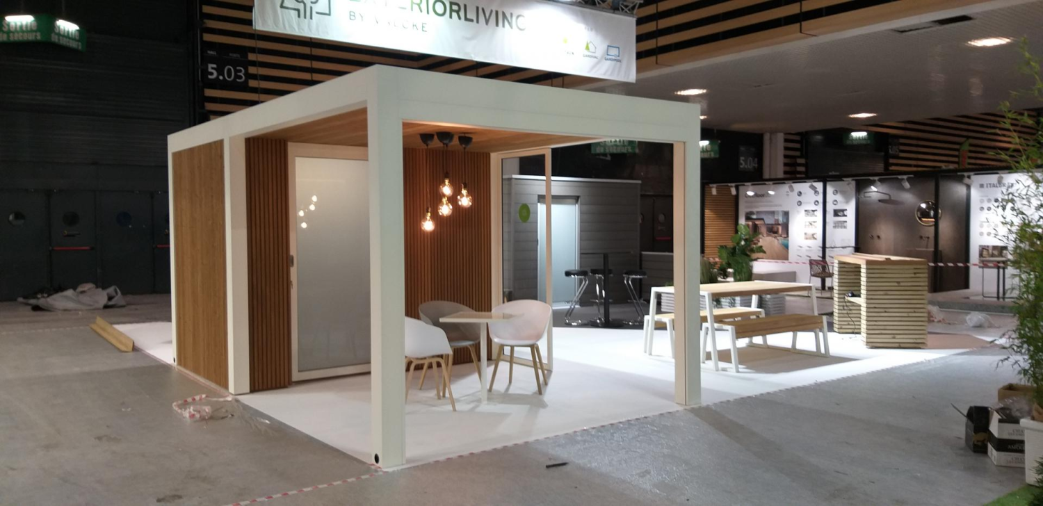 Studio de jardin blanc à bardage bois clair et baie dépolie sur stand d'exposition