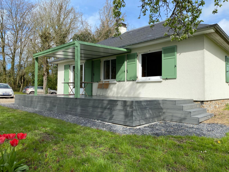 Pergola vert sauge sur terrasse grise, volets assortis et maison crépi beige