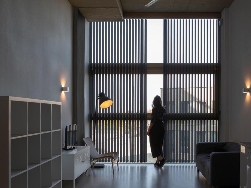 Store californien à bandes verticales noires sur grande baie dans un salon