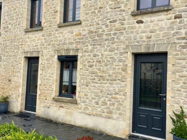 Menuiseries anthracite sur maison pierre, volet roulant solaire, terrasse ardoise