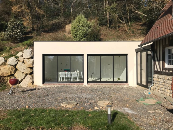 Extension toit plat, deux baies coulissantes noires, gravier devant, colombages