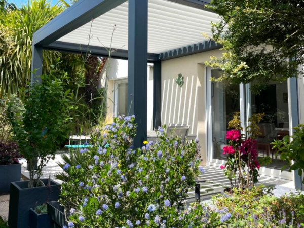 Pergola bioclimatique anthracite, lames blanches orientables, terrasse devant baie vitrée