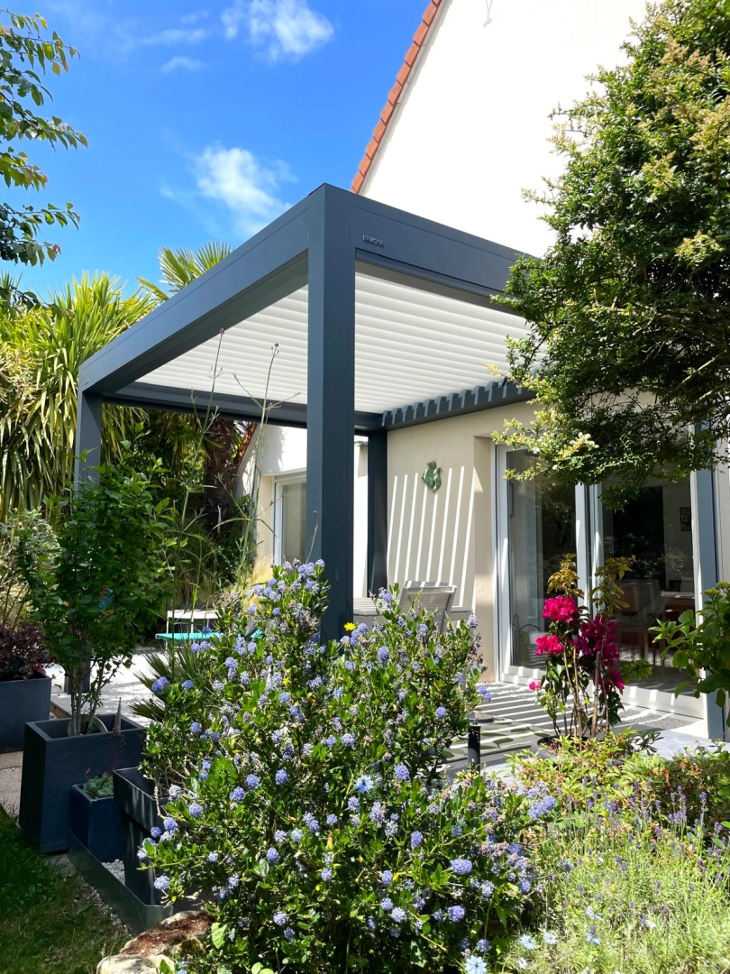 Pergola bioclimatique anthracite, lames blanches orientables, terrasse devant baie vitrée